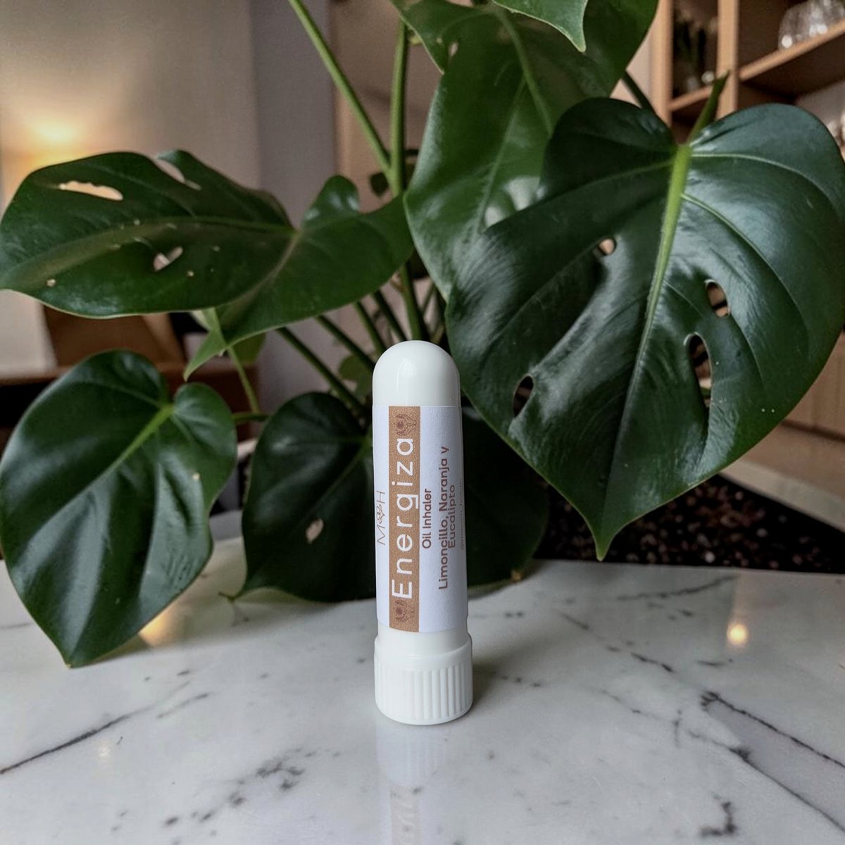 Inhalador aromático Energiza de Mayam Holistic con aceites de limoncillo, naranja y eucalipto sobre mesa de mármol.