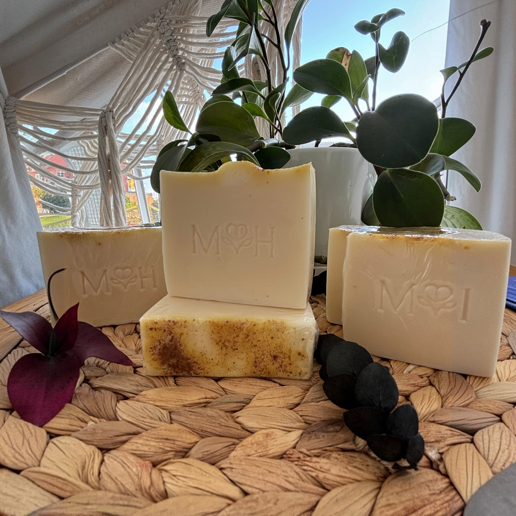 Jabón artesanal Mayam Holistic de glicerina vegetal con cúrcuma y aceites esenciales cítricos sobre base de mimbre.